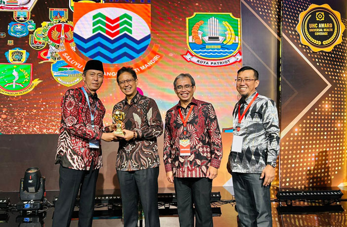 Menteri Kesehatan RI Budi Gunawan Sadikin menyerahkan penghargaan UHC kepada Bupati H Iskandar Kamaru