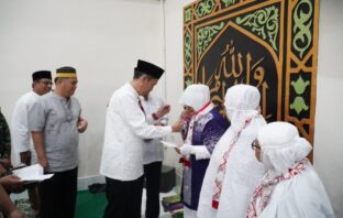 Bupati Bolsel Hi Iskandar Kamaru SPT MSi saat memberikan selamat beserta pemberian uang saku kepada 15 JCH Bolsel. (Foto: Istimewa)