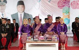 Bupati dan Wakil Bupati Bolsel tampak serasi dengan pakaian adat pada upacara peringatan HUT ke-17 Bolsel, 21 Juli 2025. (Foto: IST)