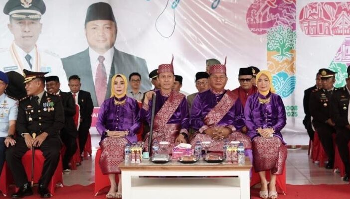Bupati dan Wakil Bupati Bolsel tampak serasi dengan pakaian adat pada upacara peringatan HUT ke-17 Bolsel, 21 Juli 2025. (Foto: IST)