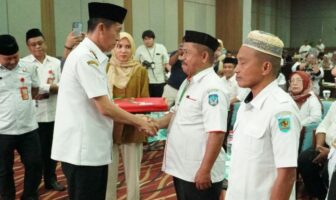 Bupati Iskandar Kamaru secara simbolik menyematkan kartu identitas kepada peserta bimtek, Manado, 23 September 2025. (Foto: IST)