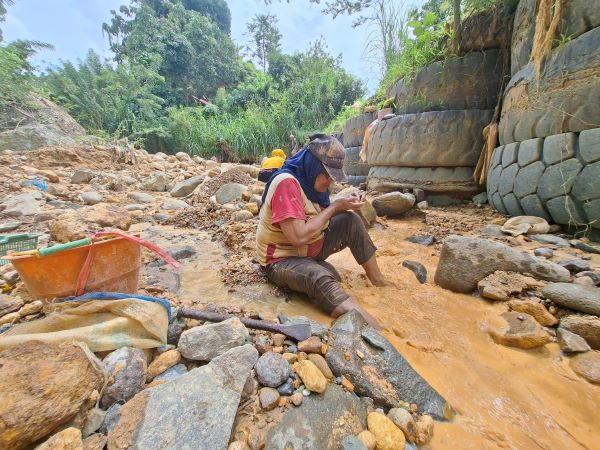 Mendulang emas. Atini Mamonto (70) memilah bebatuan di sungai bekas buangan aktivitas tambang emas rakyat di hulu perbukitan Desa Lanut, Senin 4 Mei 2026. (Foto: tim Instink.net)