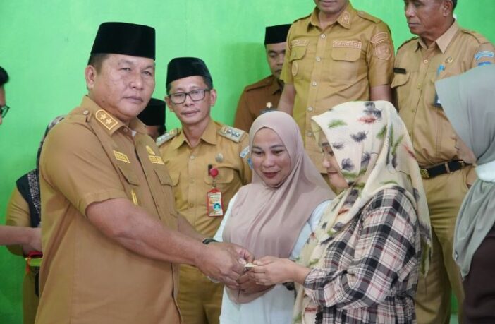 Wabup Bolsel Deddy Abdul Hamid secara simbolis menyerahkan bantuan unit rumah kepada masyarakat pesisir Desa Motandoi Selatan, Senin 29 Juni 2026. (Foto: IST)