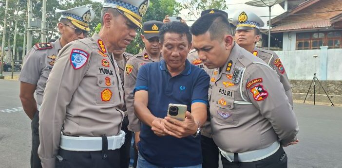 Ketua Panitia Penyelenggara Drag Race Lucky Sugeha (tengah) menunjukkan bukti rekaman pada saat kejadian kepada Dirlantas Polda Sulut Kombes Pol Yudi Kristianto (kiri) dan Korlantas Polda Sulut AKBP Sandhi Wiedyanoe (kanan) di lokasi TKP Kelurahan Upai, Selasa 11 Agustus 2026. (Foto: Faisal Manoppo/Instik.net)